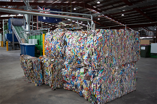 Compressed bales of used beverage cartons waiting to be recycled at a saveBOARD facility