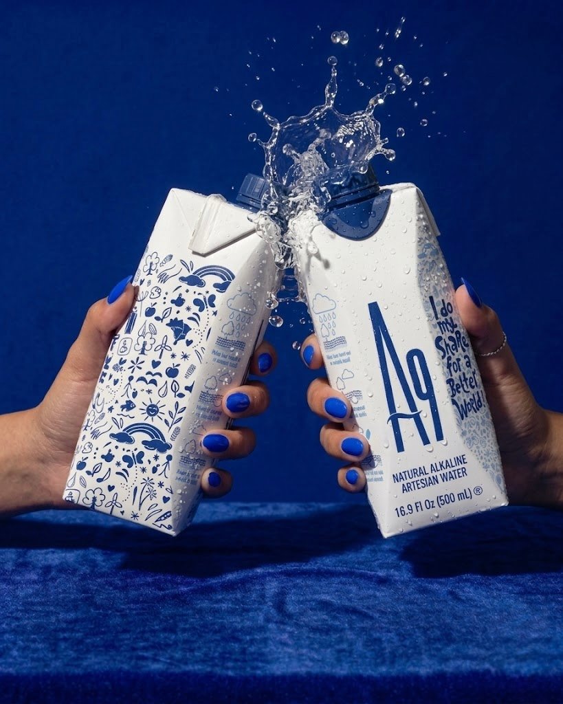 Two A9 water cartons raised together with a splash of water